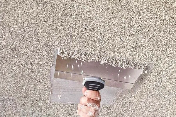 Popcorn texture removal process: Hand scraping a ceiling in preparation for a smooth, modern finish.