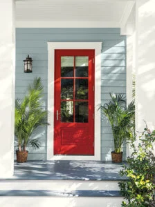 The front door of asea blue color siding and creamy cassing colors  painted beatifully with an accent red